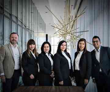 Smiling team in suits posing for a group photo.