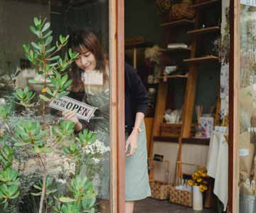 Woman turning open sign on small business