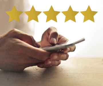 Five yellow stars overlaid on image of a hand holding a phone. 