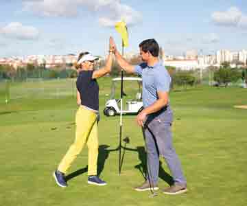 Man and woman high five on the field.