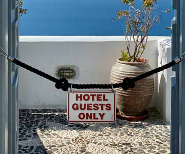 A white metal sign hangin on rope stating Hotel Guest Only.