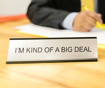 Metal desk plate that reads I'm kind of a big deal, sitting on a desk.