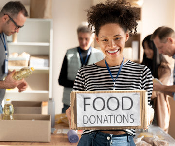 Young Smiling Woman With A Group Of Volunteers In A Bright Office Wearing Name Badges Around Their Neck