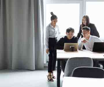 Team of colleagues focused on a laptop together.