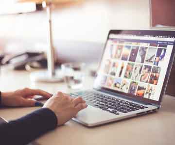 Person working behind a laptop, focused and engaged.
