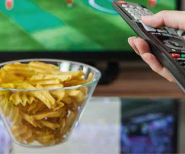 Bowl of chips in hand, remote ready Super Bowl watching mode.
