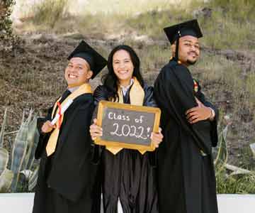 Three students taking a graduation photo.