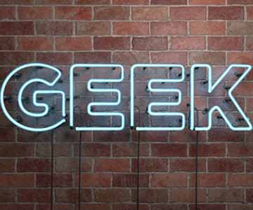 Teal Neon Geek Sign on Brick Wall