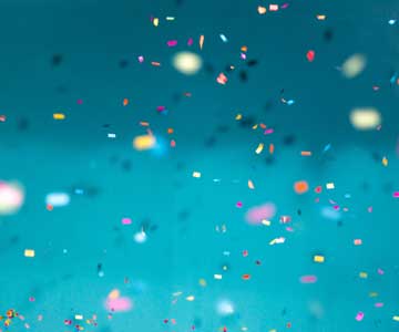 Confetti falling down on a teal background.