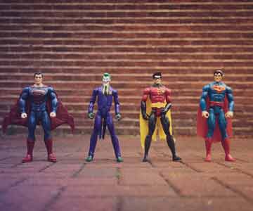 A collection of superhero and super villain toys standing next to each other.