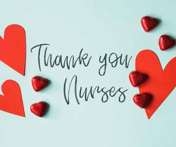 Thank you Nurses written on a blue surface surrounded by candy and paper hearts.
