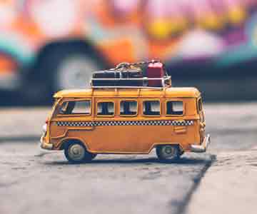 Small toy bus truck on a wooden surface.
