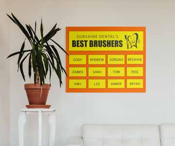 An orange acrylic plaque with yellow plastic plates, hanging on a wall.