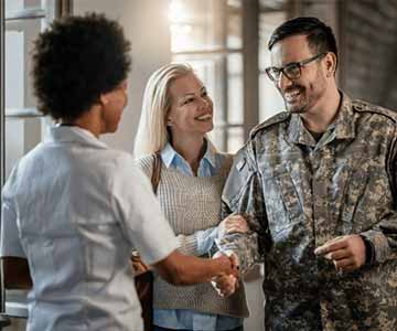 Happy veteran and wife meeting a friend.