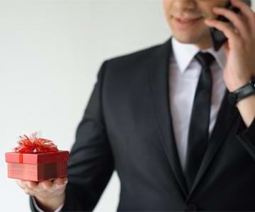 Businessman In Black Suit Holding Red Gift For Boss