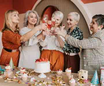 Smiling seniors raise their glasses in cheer.