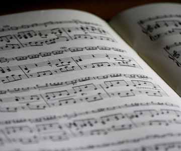 An open book that has sheet music in it.