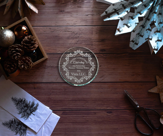 Custom Circle Shaped Glass Paperweight Engraved With Corporate Christmas Message On Wood Table With Christmas Decor