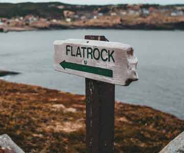 Arrow sign showing direction beside a beach.