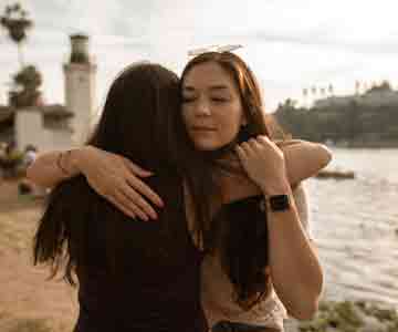 A comforting hug shared between two women.