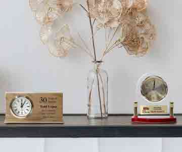 Two clocks beside a stylish vase display