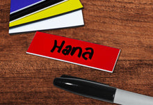 Blank Plastic Name Tags With Handwritten Name In Permanent Marker.