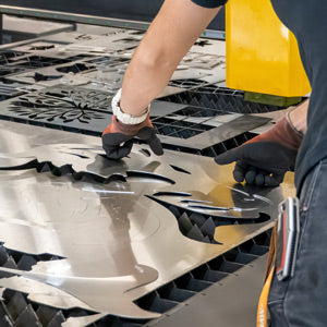Worker Organizing Newly Laser Cut Stainless Steel Metal