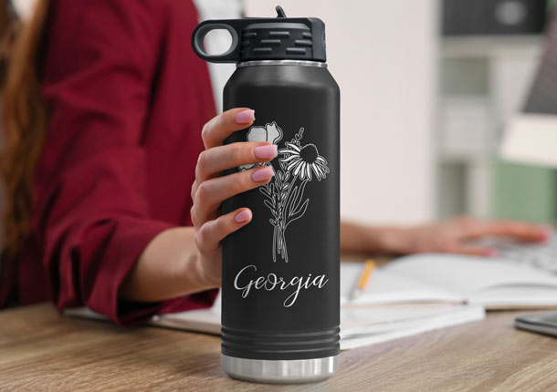 Woman Reaching For Black Engraved Water Bottle.
