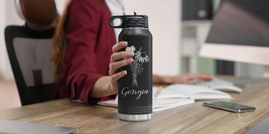 Woman Reaching For Black Engraved Water Bottle.