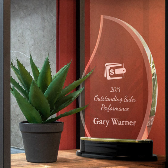Custom Flame Shaped Acrylic Award For Sales With Logo And Name And Gold Mirror Base On Wood Shelf With Potted Plant
