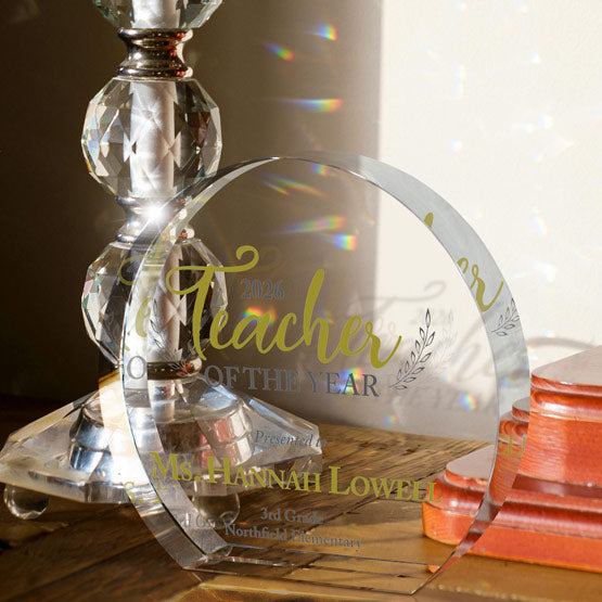 Freestanding Circle Shaped Glass Award Printed With Teacher Of The Year Message On Wood Desk With Glass Candle Holder