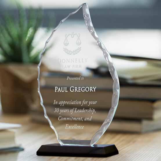 Custom Faceted Flame Glass Award For Years Of Service With Law Firm Logo And Black Base On Wood Desk With Books And Plant
