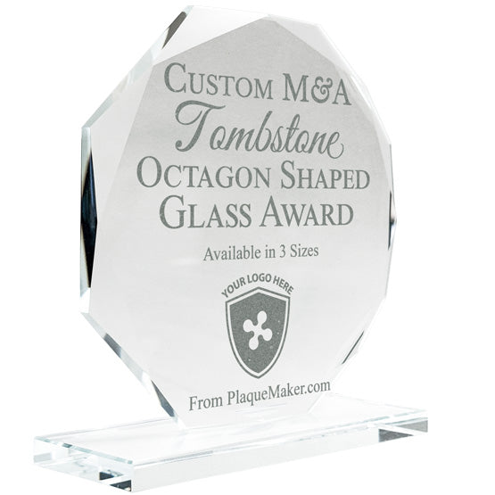 A clear octagonal glass award on a glass base, engraved with custom text and placeholder art, set at a slight angle and shown on a white background.