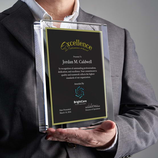 Man In Business Suit Holding Rectangle Glass Award With Black Screen Printed With Excellent Performance Message And Logo