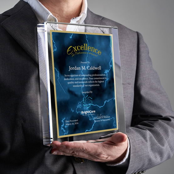 Man In Business Suit Holding Rectangle Glass Award With Blue Screen Printed With Excellent Performance Message And Logo