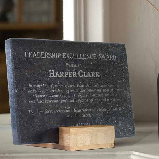 Custom Black Granite Award For Leadership Excellence With Message And Custom Cut Bamboo Base On White Shelf In Living Room