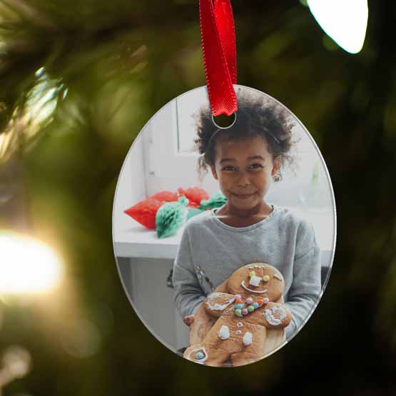 Custom Oval Acrylic Ornament With Red Ribbon And Full Color Photo Of Child Holding Out Gingerbread Man At Home