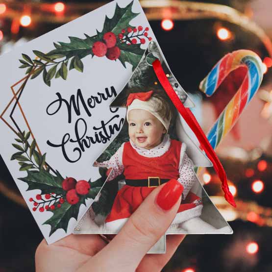 Hand Holding Christmas Card And Custom Tree Shaped Acrylic Ornament With Red Ribbon And Full Color Photo Of Festive Baby