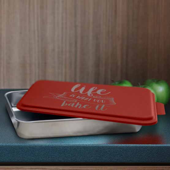 Custom Aluminum Cake Pan With Red Lid Featuring Life Is What You Bake It Text On Blue Kitchen Counter With Green Apples