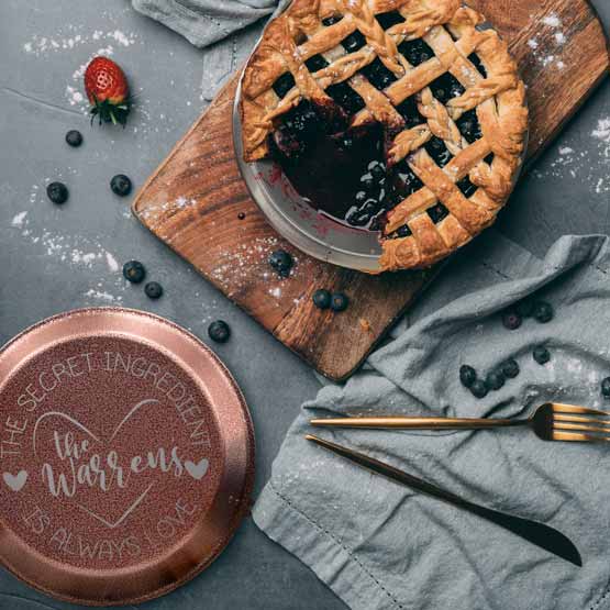 Custom Nine Inch Aluminum Pie Pan With Copper Lid Featuring Family Name And Secret Ingredient Is Love Text On Table With Pie