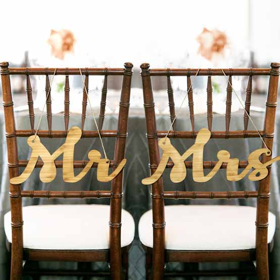 Pair Of Custom Bamboo Chair Signs Featuring Cutouts Of Cursive Mister And Missus Titles Hanging On Wedding Chairs Via String