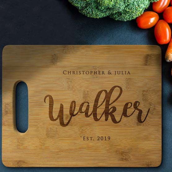 Custom Bamboo Cutting Board Laser Engraved With Family Names And Date On Blue Table With Vegetables
