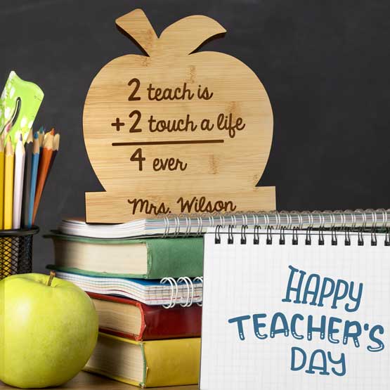 Custom Apple Shaped Bamboo Name Plate With Name And Teacher Appreciation Message On Classroom Desk With Books And Notepads