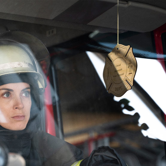 Woman Driving Fire Truck With Custom Maltese Cross Bamboo Ornament Hanging By Front Windshield Via Gold String