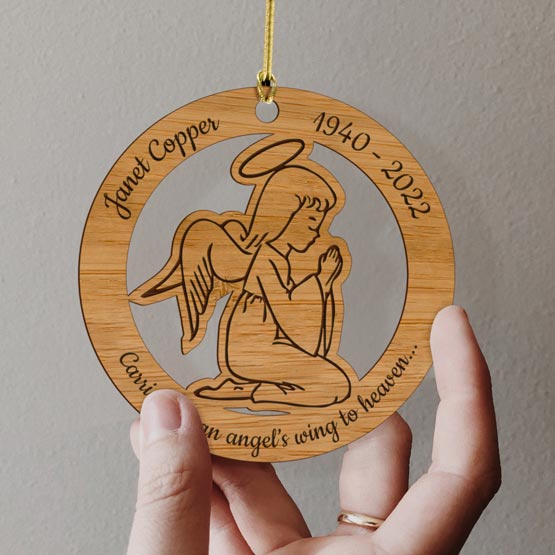 Hand Holding Custom Circle Bamboo Ornament With Angel Cutout And Art And Memorial Message With Name And Dates