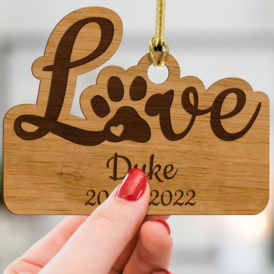 Woman Hand Holding Custom Memorial Bamboo Ornament Engraved With Love Text And Paw Print And Dog Name And Years Lived