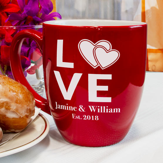 Custom Red Ceramic Bistro Mug Engraved With Hearts Inside The Word Love And Names And Date On Table With Donuts And Flowers