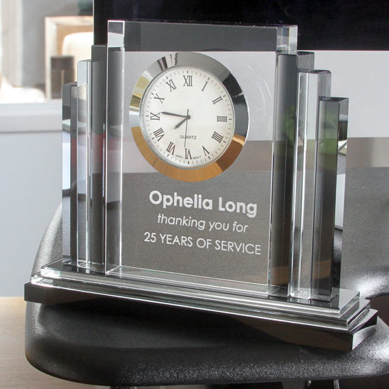 Custom Art Deco Shaped Glass Desk Clock With Black Base And Engraved With Years Of Service Appreciation Text On A Work Desk