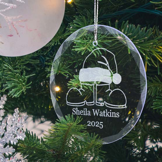 Circle Glass Christmas Ornament Engraved With Santa Hat On Boots Art And Name And Year Hanging On Christmas Tree Via String