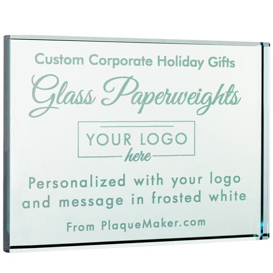 A square custom glass paperweight with frosted white and pale mint lettering that reads 'Custom Corporate Holiday Gifts Glass Paperweights YOUR LOGO here Personalized with your logo and message in frosted white From PlaqueMaker.com'.